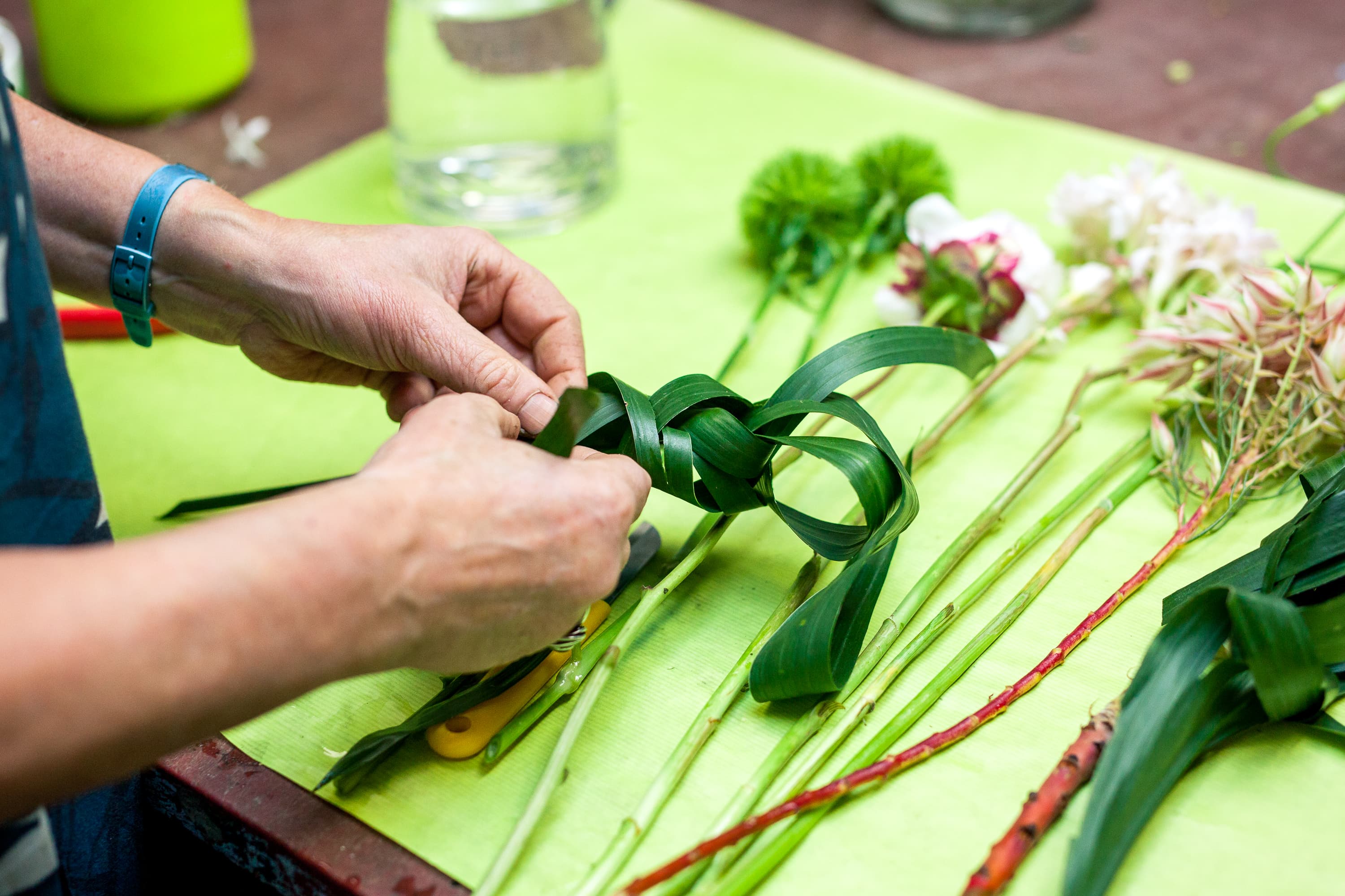 Foto van Diny Blom of een van haar klanten tijdens de voorbereiding voor boeketten voor een trouwerij. De foto’s geven met een sfeer van kleur, vrolijkheid en inspiratie een goed beeld van het prachtige werk van Diny Blom.