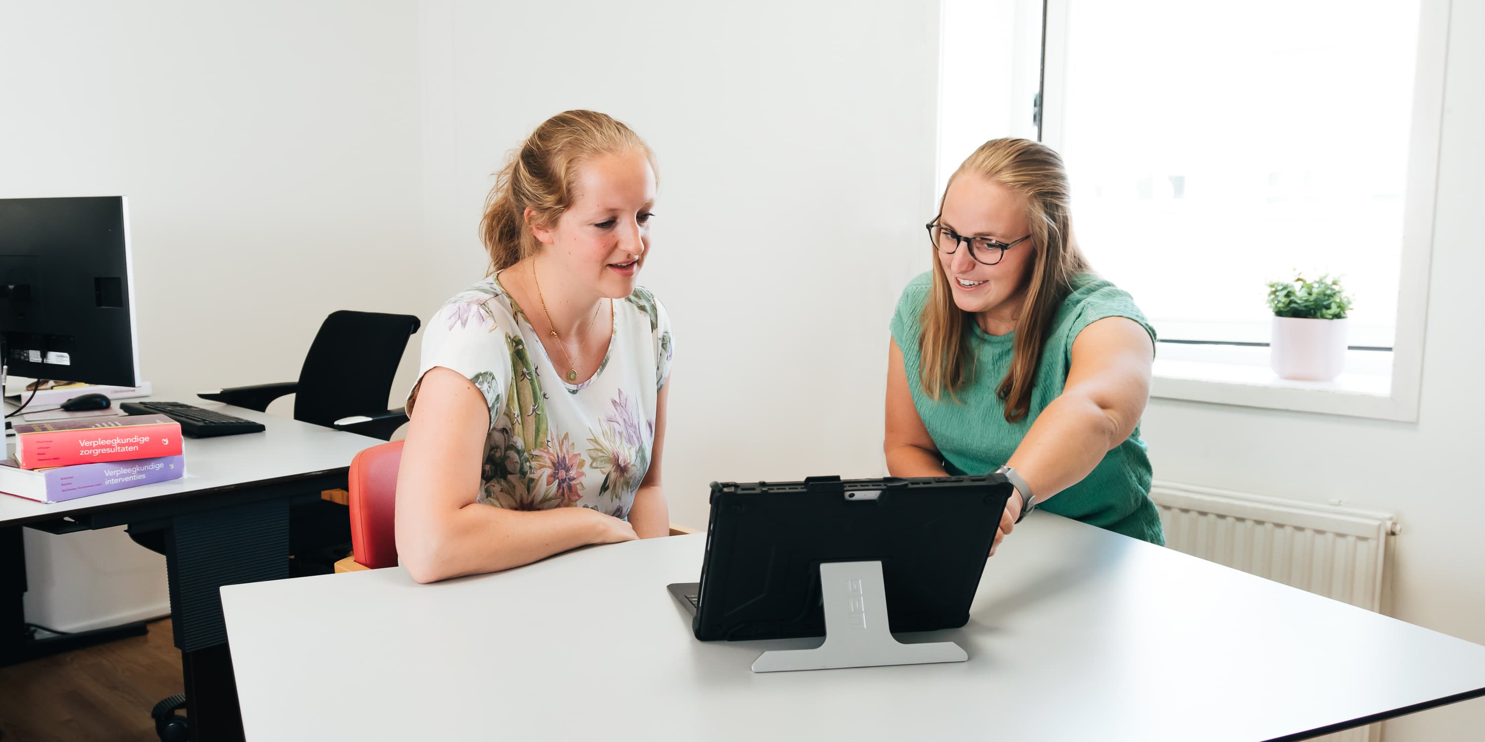 Foto van een medewerker of een groep medewerkers van Vierstroom Zorg Thuis die hun werk doen of samen plezier hebben, met een uitstraling van passie, betrokkenheid en gezelligheid