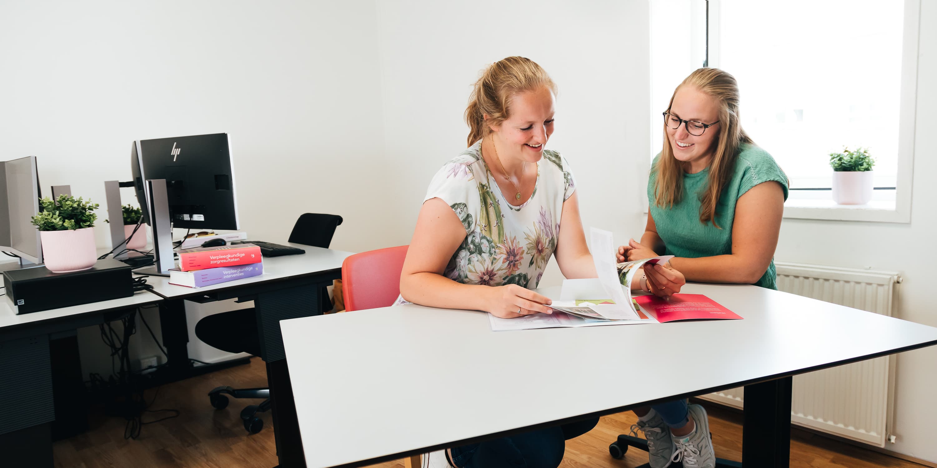 Foto van een medewerker of een groep medewerkers van Vierstroom Zorg Thuis die hun werk doen of samen plezier hebben, met een uitstraling van passie, betrokkenheid en gezelligheid