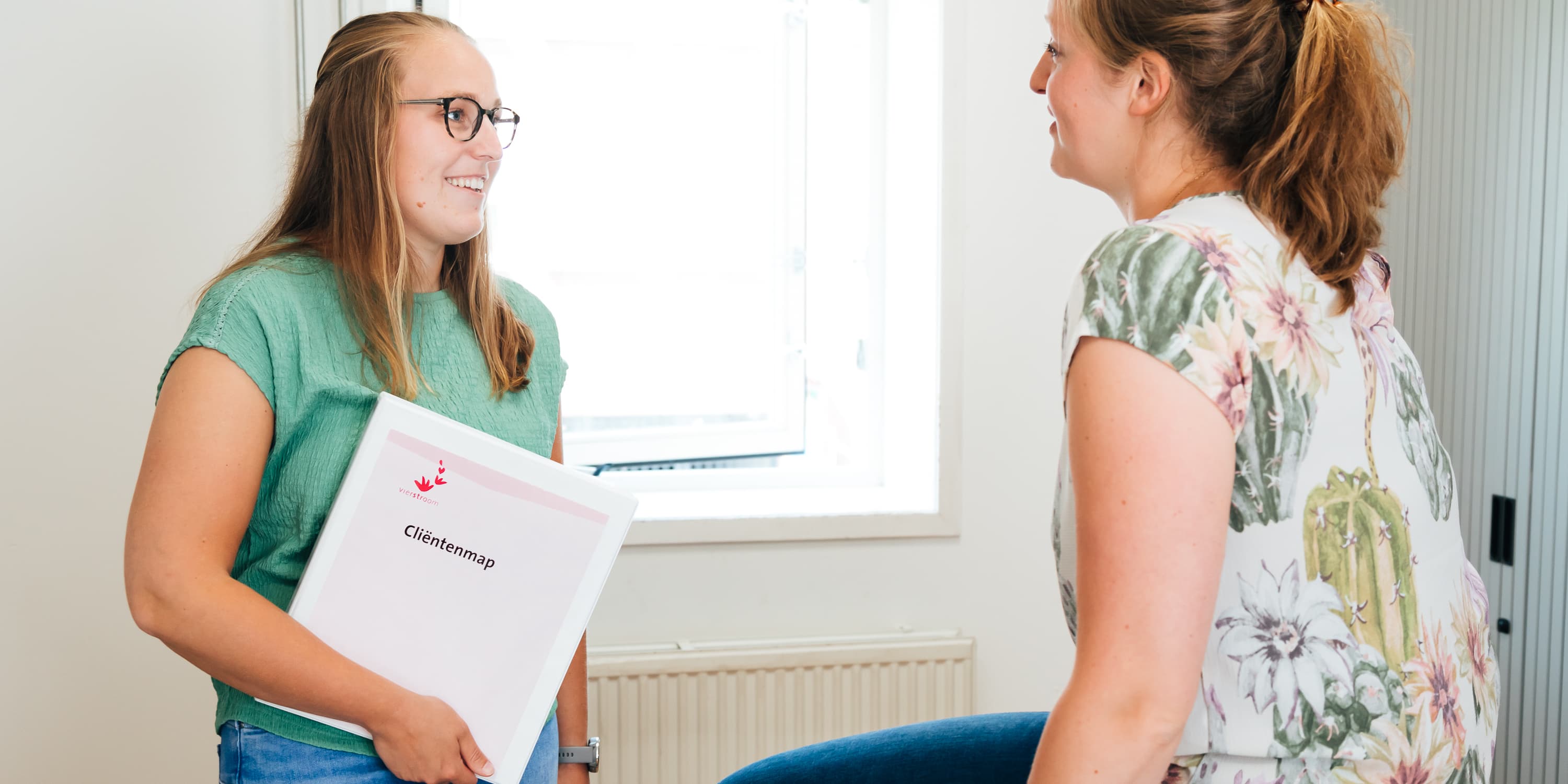 Foto van een medewerker of een groep medewerkers van Vierstroom Zorg Thuis die hun werk doen of samen plezier hebben, met een uitstraling van passie, betrokkenheid en gezelligheid