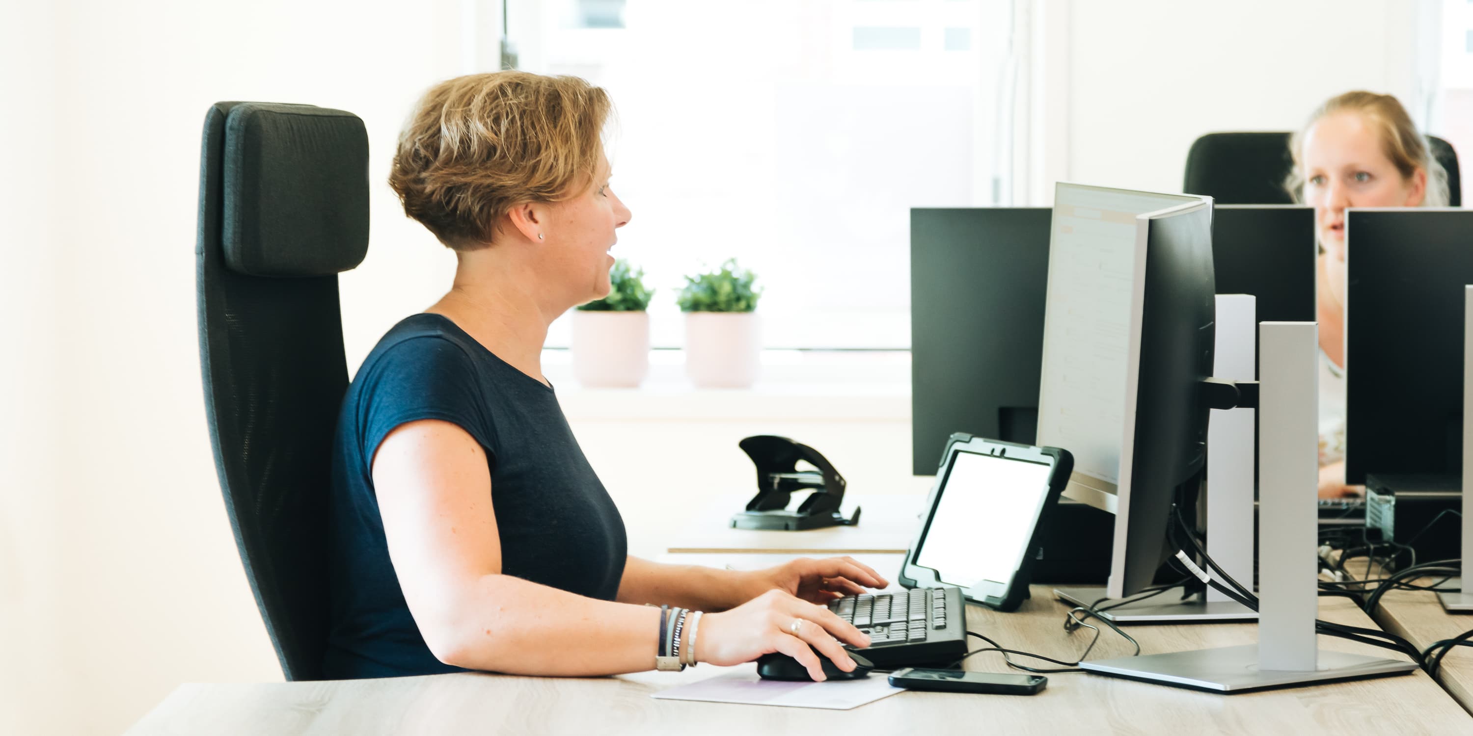 Foto van een medewerker of een groep medewerkers van Vierstroom Zorg Thuis die hun werk doen of samen plezier hebben, met een uitstraling van passie, betrokkenheid en gezelligheid