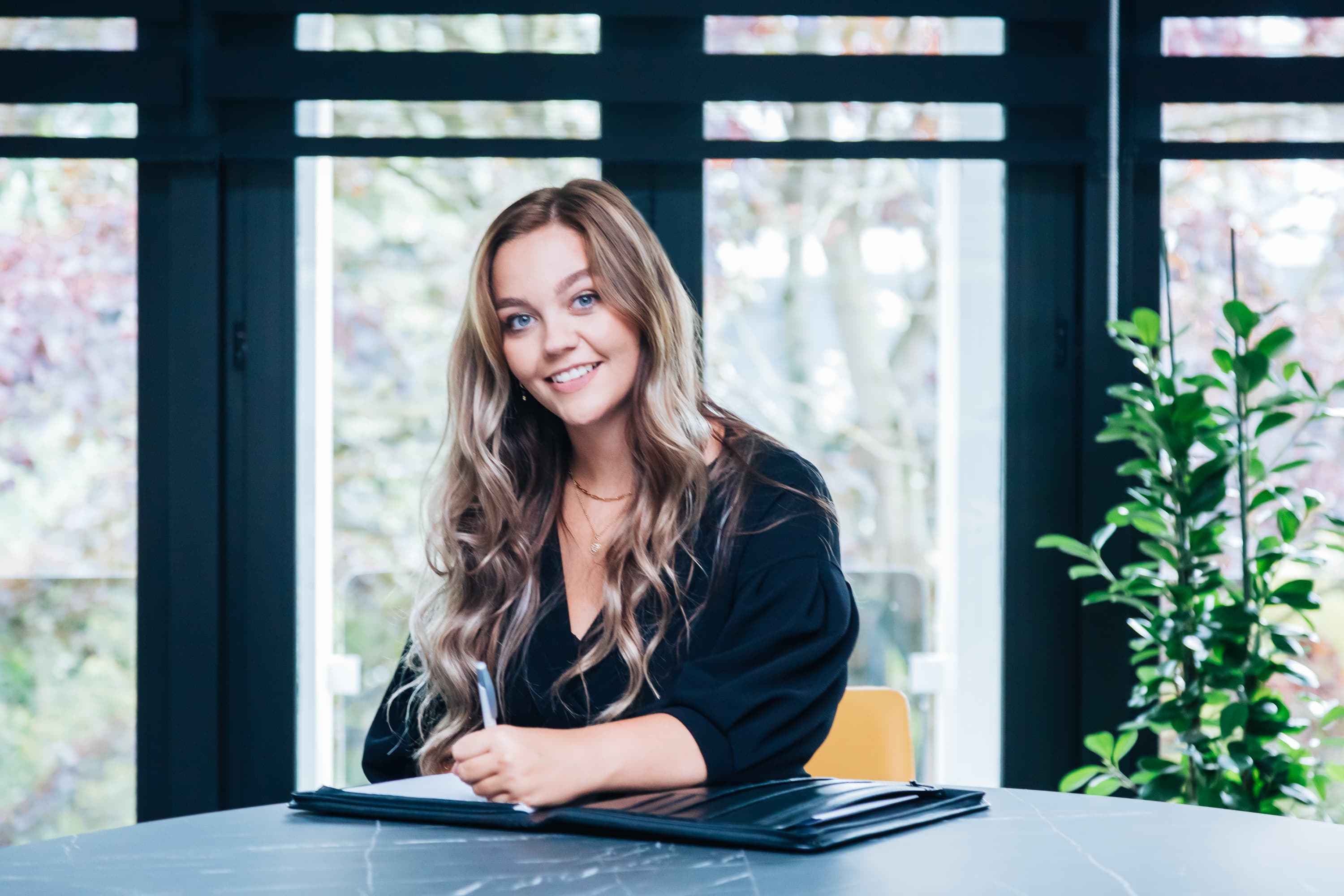 Employer Branding van een ‘Young Professional’ van Lansigt, werkend, lachend of poserend in een van de vestigingen van het accountantskantoor, namelijk Gouda.