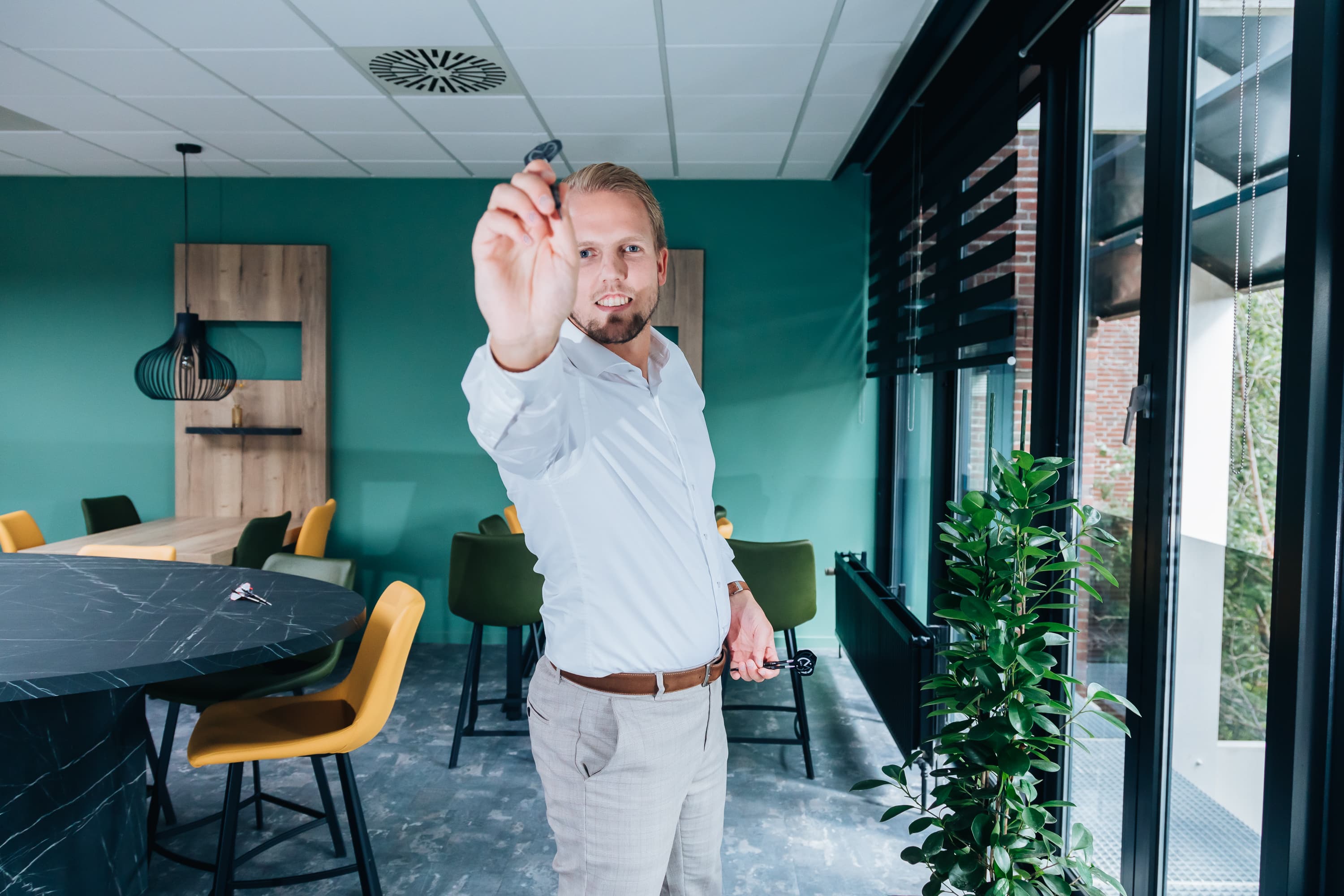 Employer Branding van een ‘Young Professional’ van Lansigt, werkend, lachend of poserend in een van de vestigingen van het accountantskantoor, namelijk Gouda.