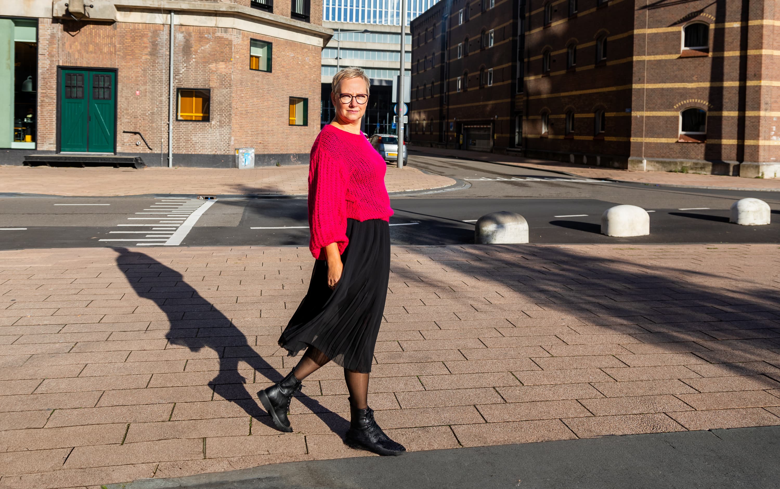 Joke van der Kraan, grafisch vormgever en eigenaar van VormBuilders, gefotografeerd in het stedelijke landschap van Rotterdam, waar haar professionele uitstraling en warme persoonlijkheid vastgelegd zijn tegen een achtergrond van dynamische architectuur.