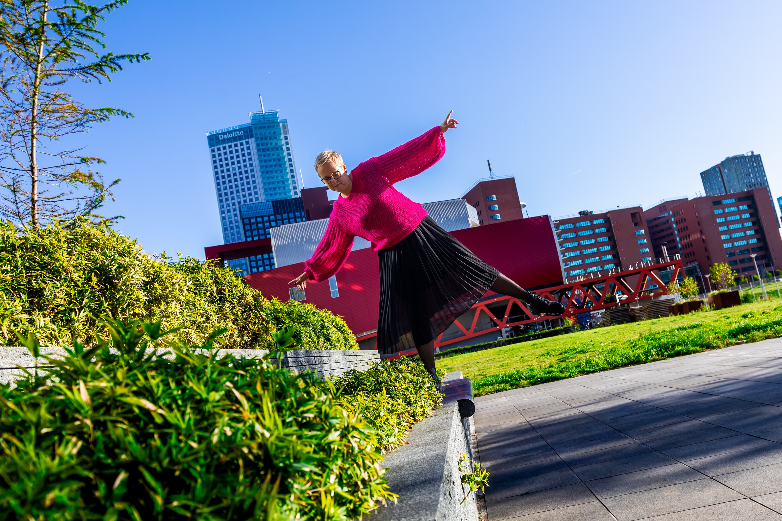 Joke van der Kraan, grafisch vormgever en eigenaar van VormBuilders, gefotografeerd in het stedelijke landschap van Rotterdam, waar haar professionele uitstraling en warme persoonlijkheid vastgelegd zijn tegen een achtergrond van dynamische architectuur.