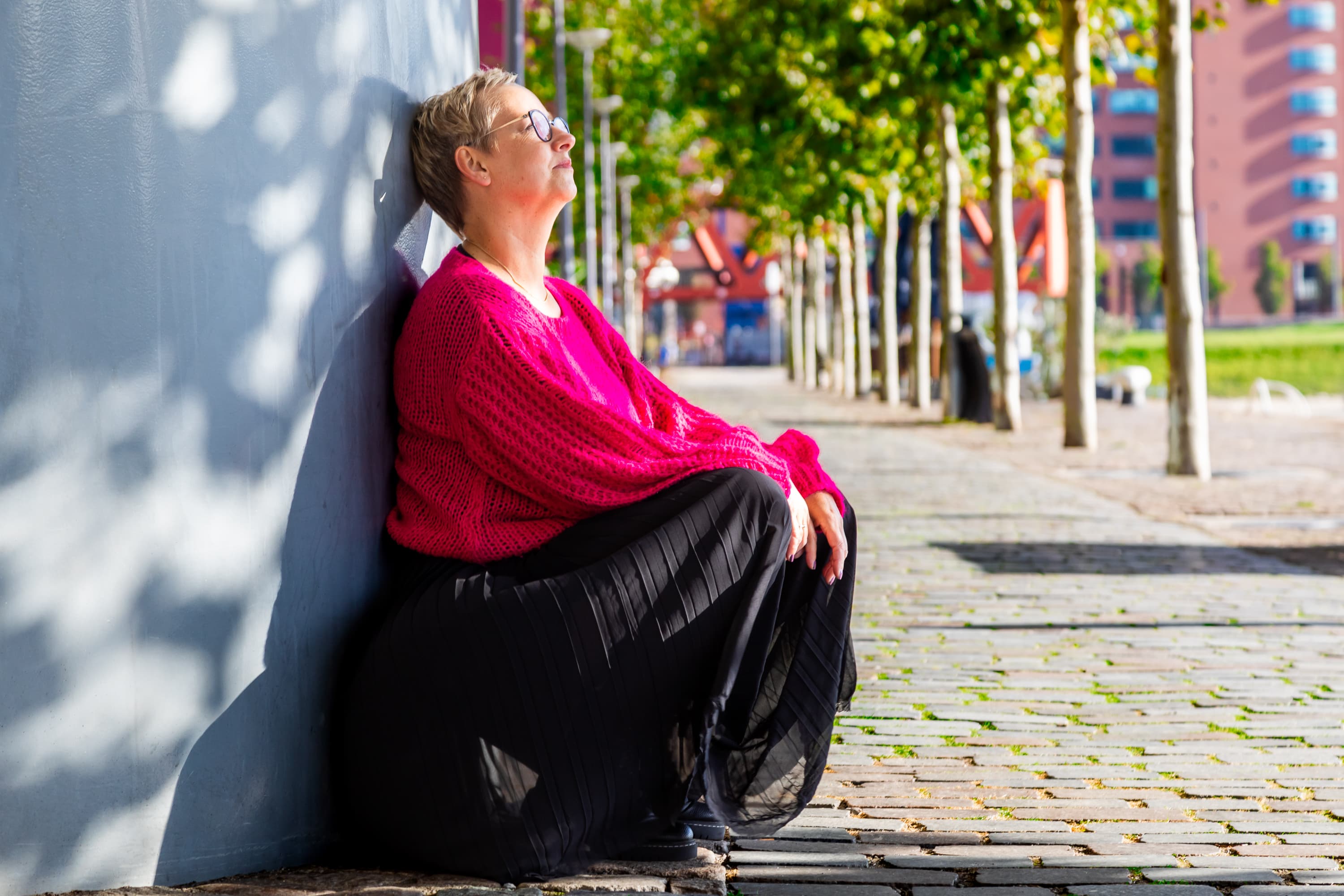 Joke van der Kraan, grafisch vormgever en eigenaar van VormBuilders, gefotografeerd in het stedelijke landschap van Rotterdam, waar haar professionele uitstraling en warme persoonlijkheid vastgelegd zijn tegen een achtergrond van dynamische architectuur.