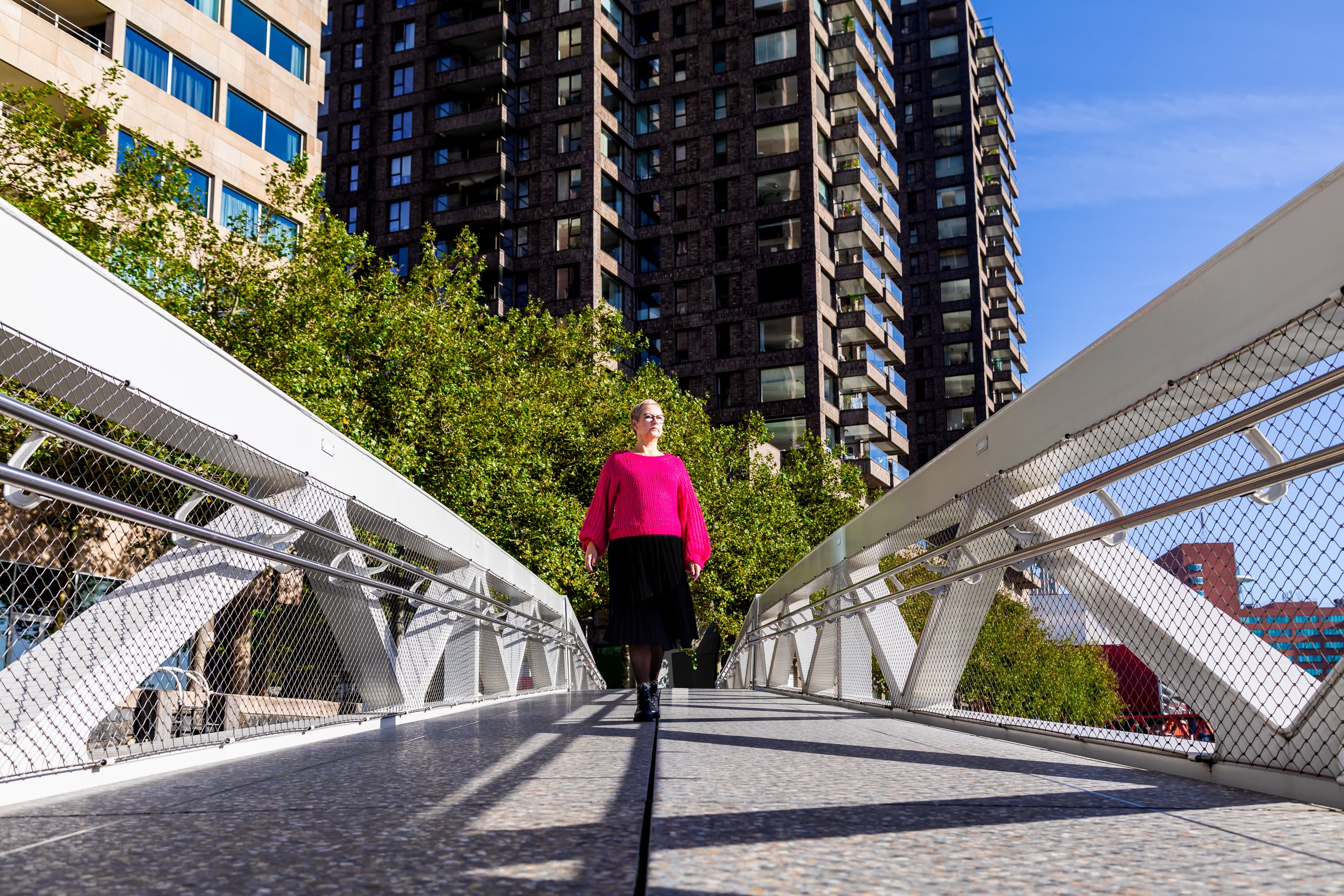 Joke van der Kraan, grafisch vormgever en eigenaar van VormBuilders, gefotografeerd in het stedelijke landschap van Rotterdam, waar haar professionele uitstraling en warme persoonlijkheid vastgelegd zijn tegen een achtergrond van dynamische architectuur.