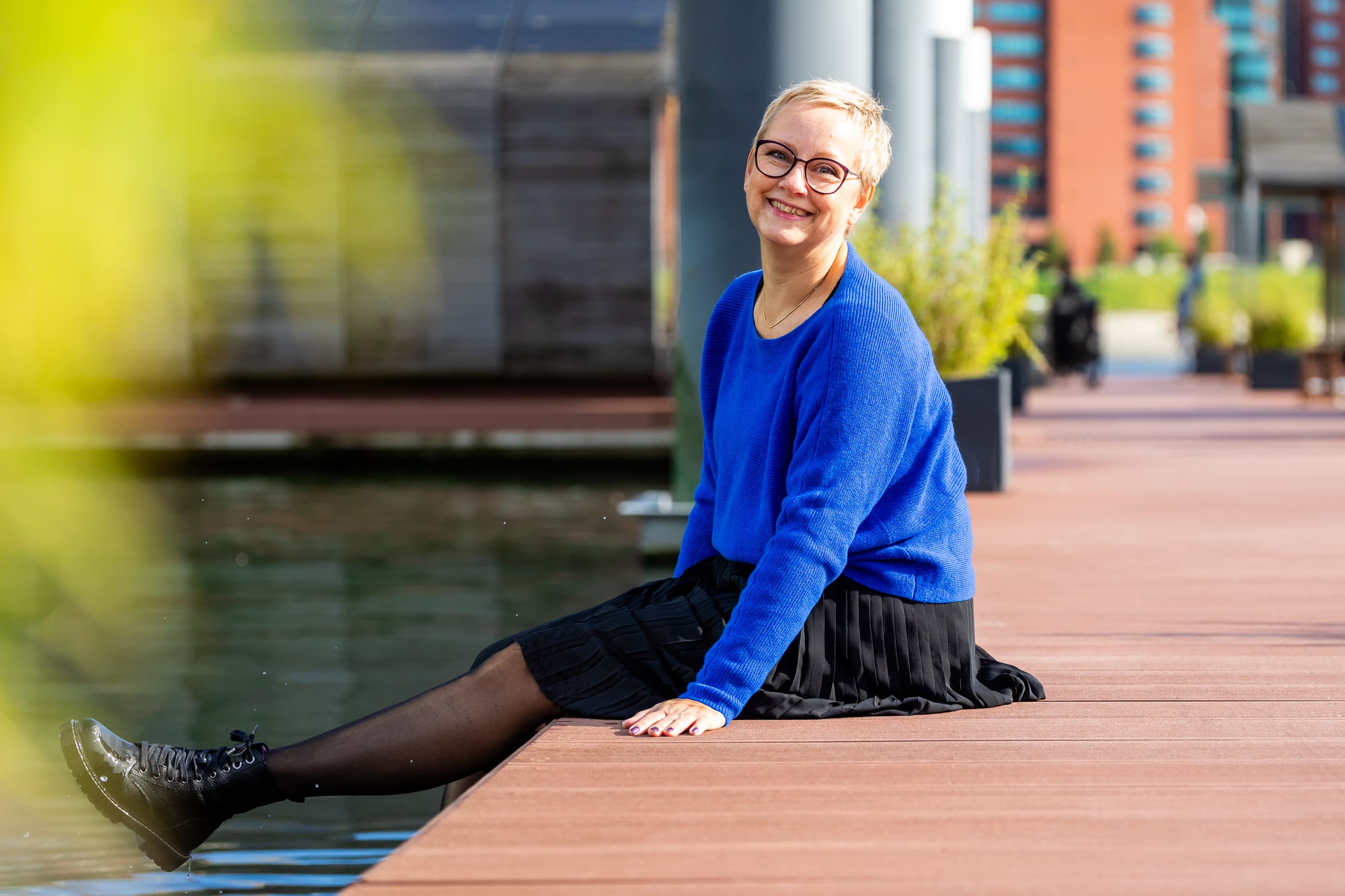 Joke van der Kraan, grafisch vormgever en eigenaar van VormBuilders, gefotografeerd in het stedelijke landschap van Rotterdam, waar haar professionele uitstraling en warme persoonlijkheid vastgelegd zijn tegen een achtergrond van dynamische architectuur.