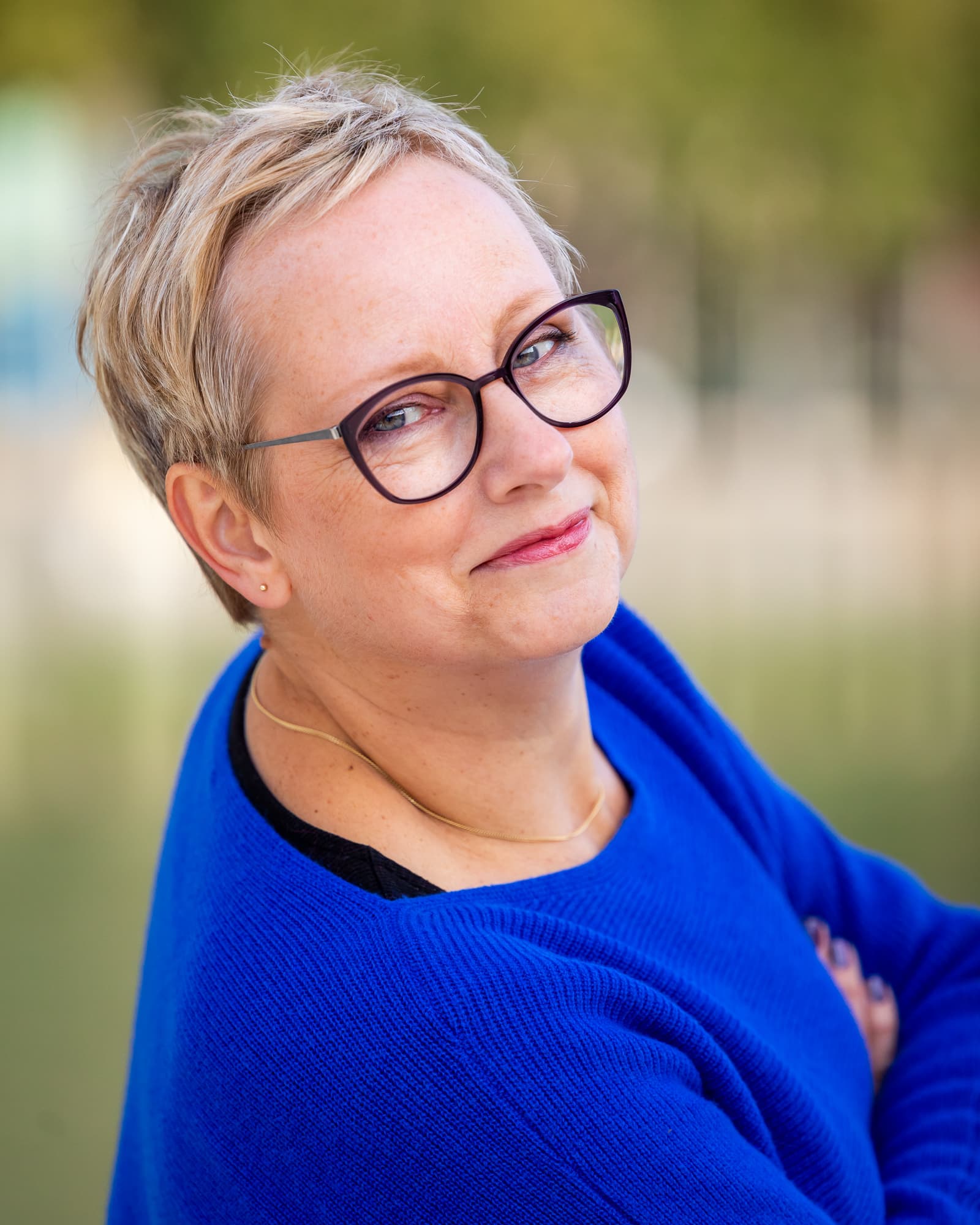 Joke van der Kraan, grafisch vormgever en eigenaar van VormBuilders, gefotografeerd in het stedelijke landschap van Rotterdam, waar haar professionele uitstraling en warme persoonlijkheid vastgelegd zijn tegen een achtergrond van dynamische architectuur.