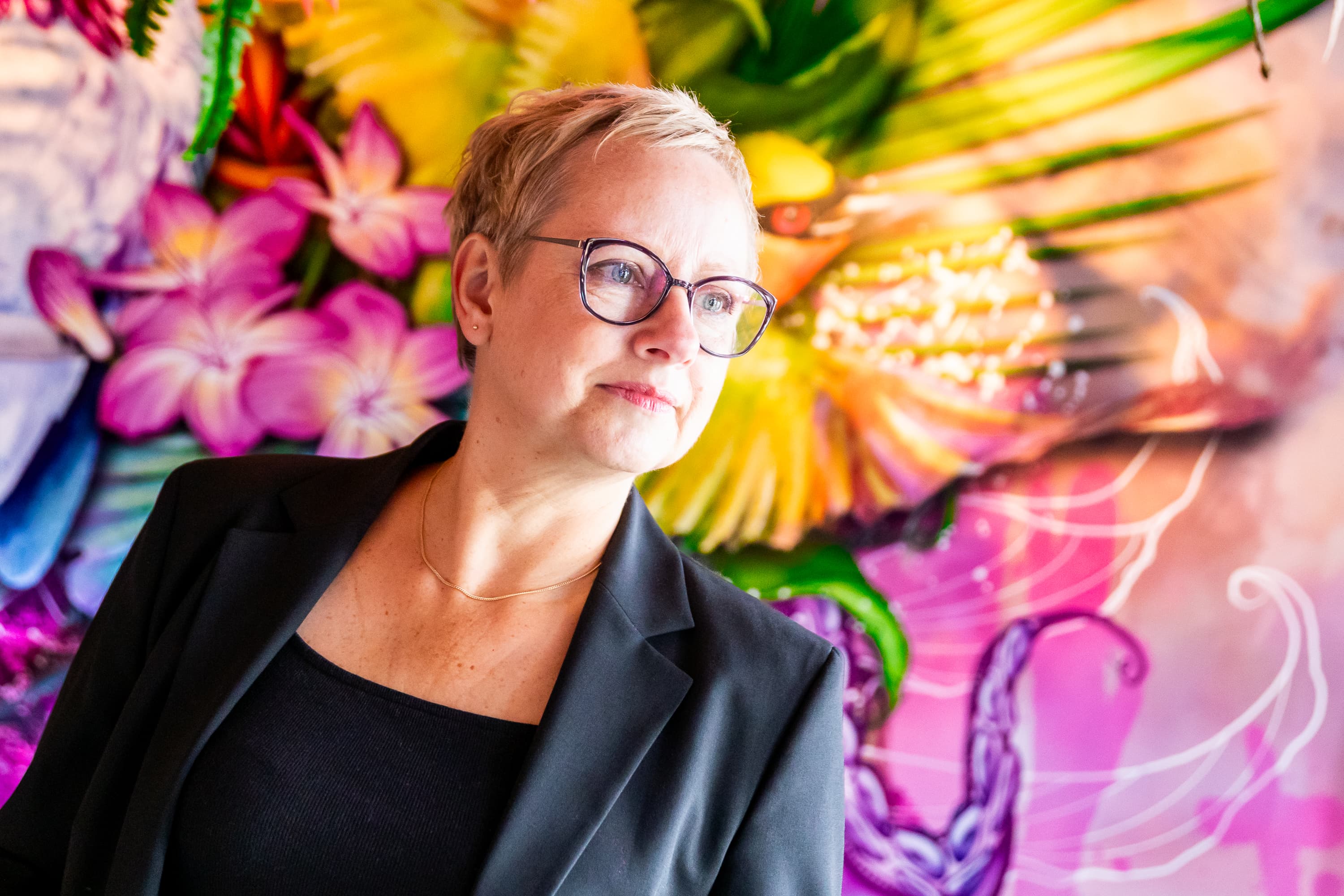 Joke van der Kraan, grafisch vormgever en eigenaar van VormBuilders, gefotografeerd in het stedelijke landschap van Rotterdam, waar haar professionele uitstraling en warme persoonlijkheid vastgelegd zijn tegen een achtergrond van dynamische architectuur.