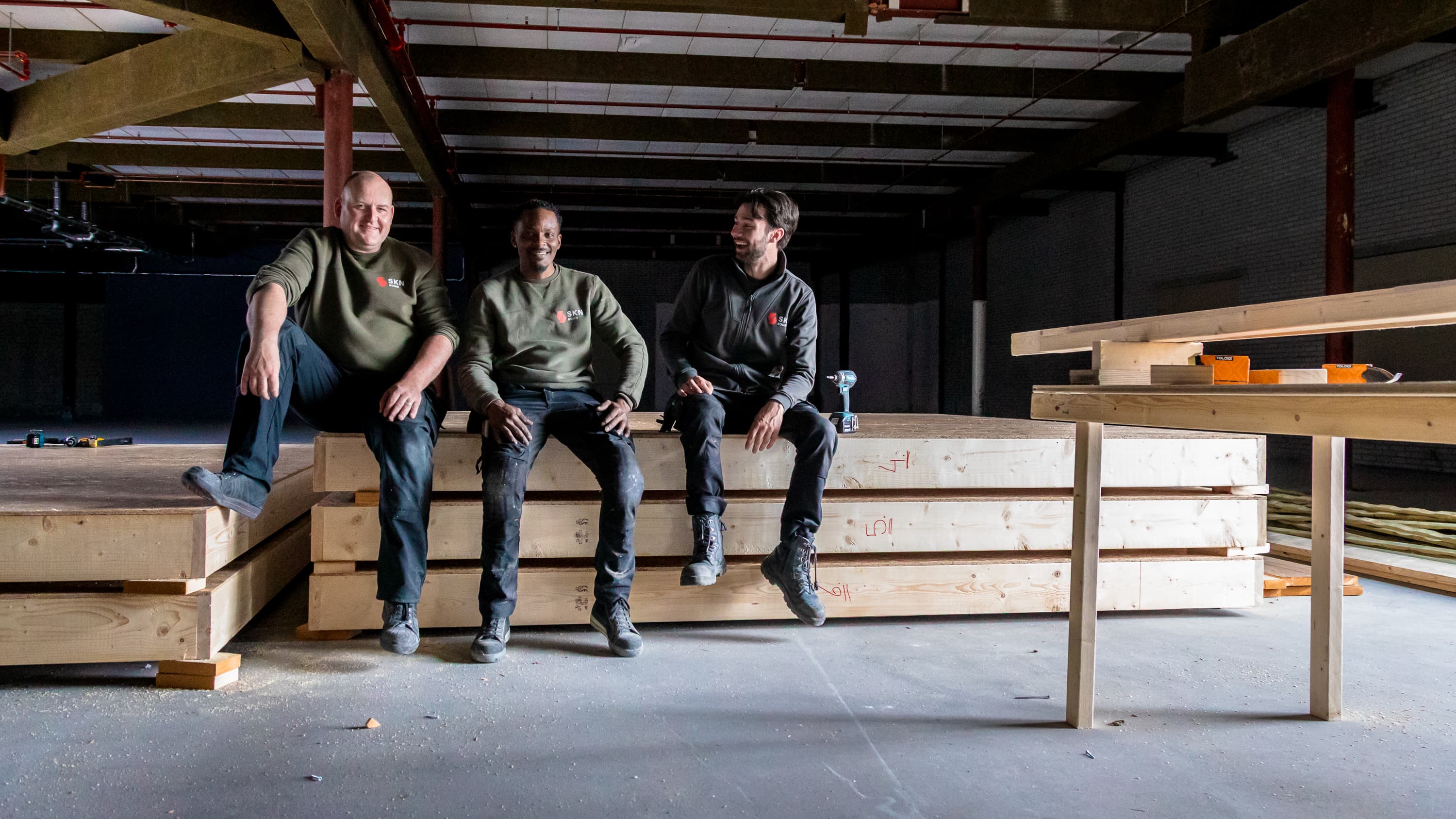 Fotoserie van Bart van den Bosch bij SKN Bouw in de Mall of the Netherlands. De beelden tonen bouwvakkers in bedrijfskleding van ViV Corporate Fashion, met aandacht voor details, vakmanschap en teamspirit.