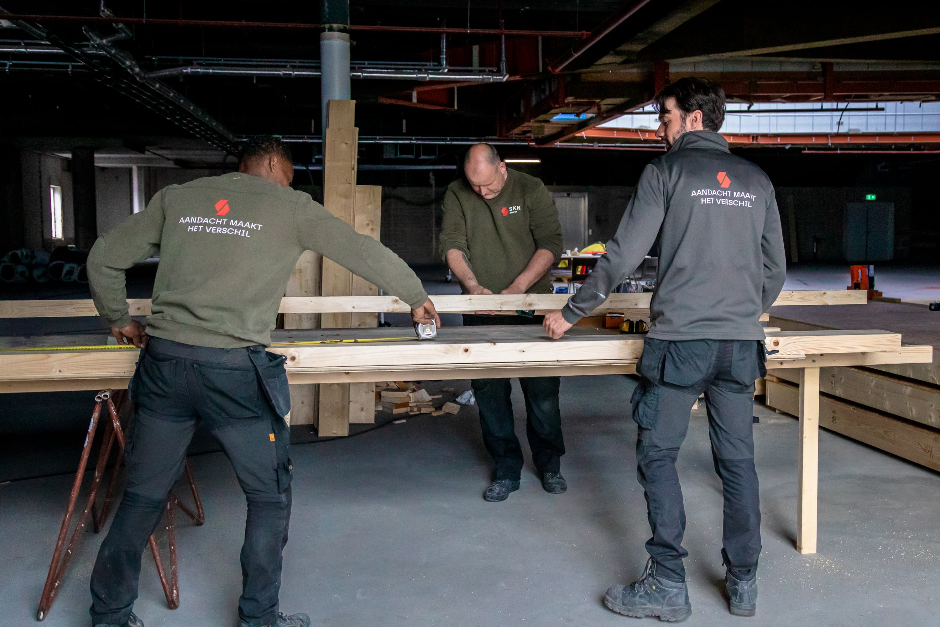Fotoserie van Bart van den Bosch bij SKN Bouw in de Mall of the Netherlands. De beelden tonen bouwvakkers in bedrijfskleding van ViV Corporate Fashion, met aandacht voor details, vakmanschap en teamspirit.